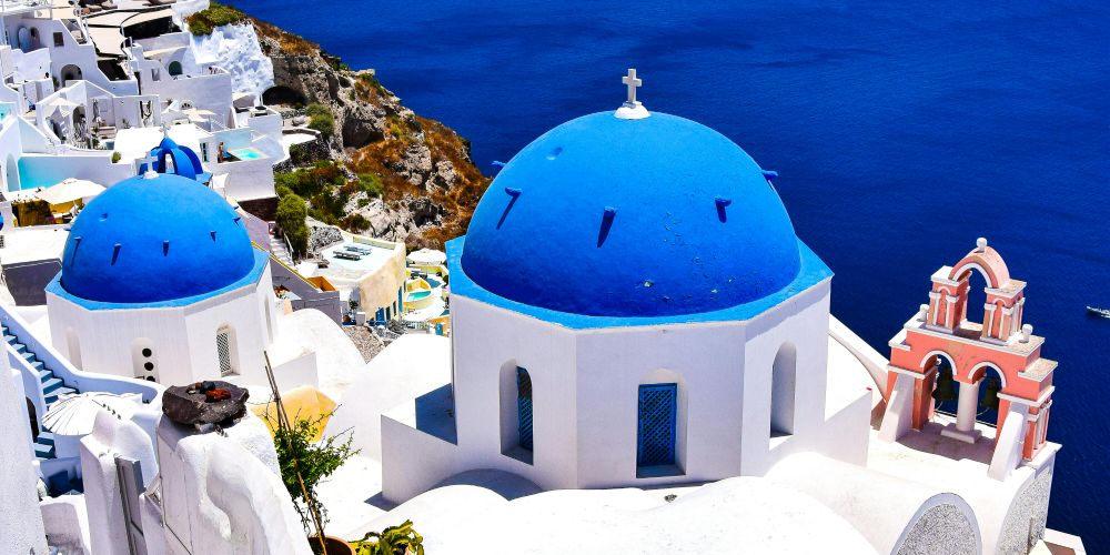 Iconic blue-domed churches in Oia, Santorini, overlooking the caldera