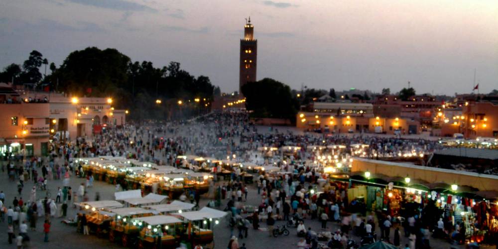 The bustling Jemaa el-Fnaa square in Marrakech at night with food stalls and performers