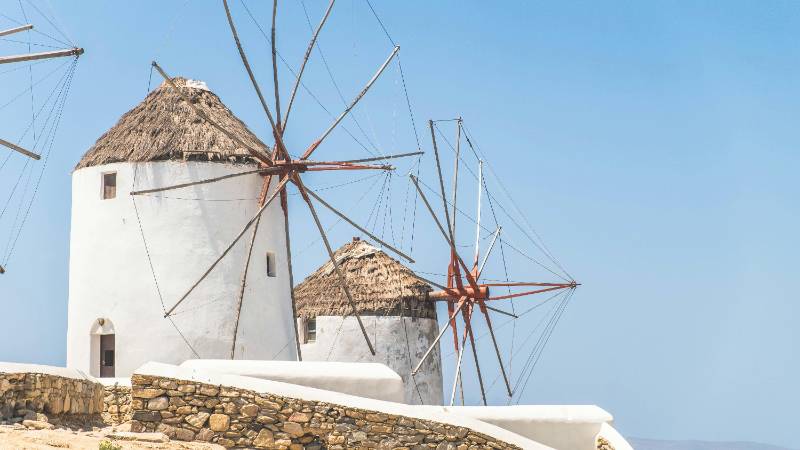 The iconic windmills of Mykonos at sunset, overlooking Little Venice