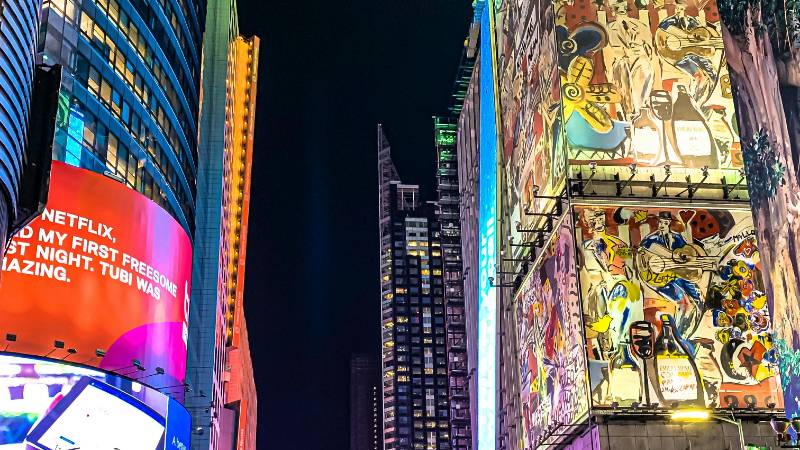 Times Square at night with bright lights and bustling crowds