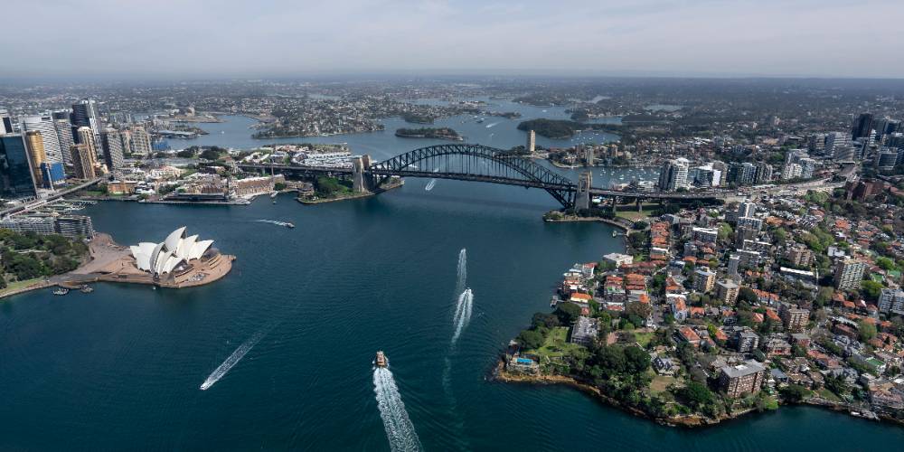 Aerial view of Sydney Harbour with the Opera House, Harbour Bridge, and city skyline