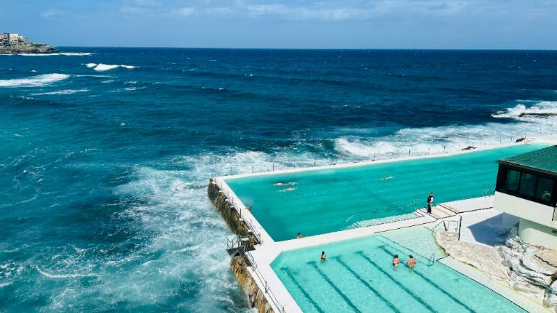 The iconic Bondi Beach in Sydney with surfers and the Icebergs ocean pool