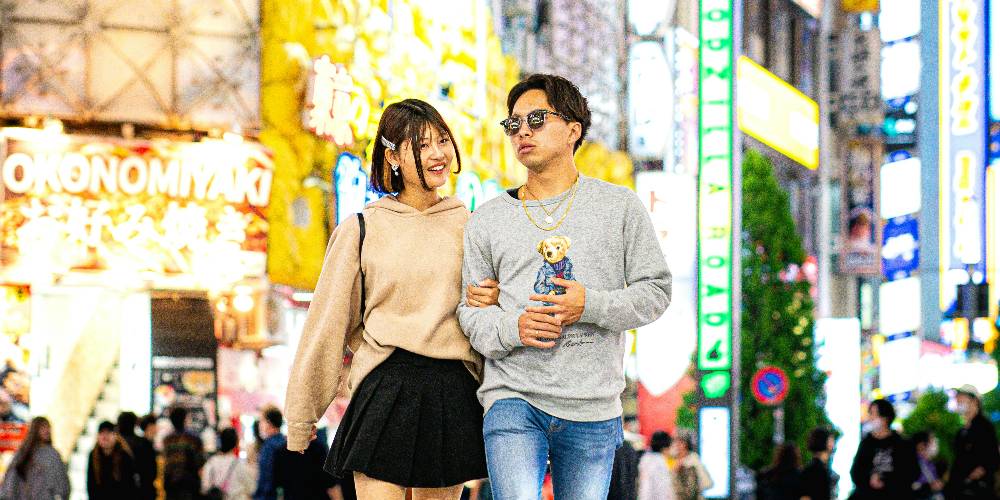 The iconic Shibuya Crossing in Tokyo at night with vibrant neon lights
