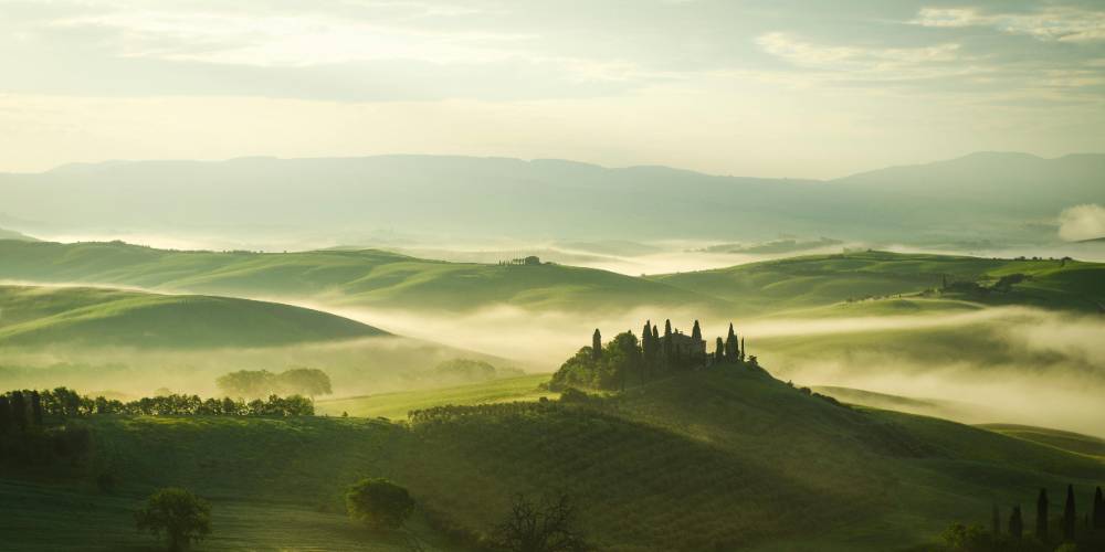 Iconic Tuscan landscape with rolling hills, cypress trees, and a rustic farmhouse