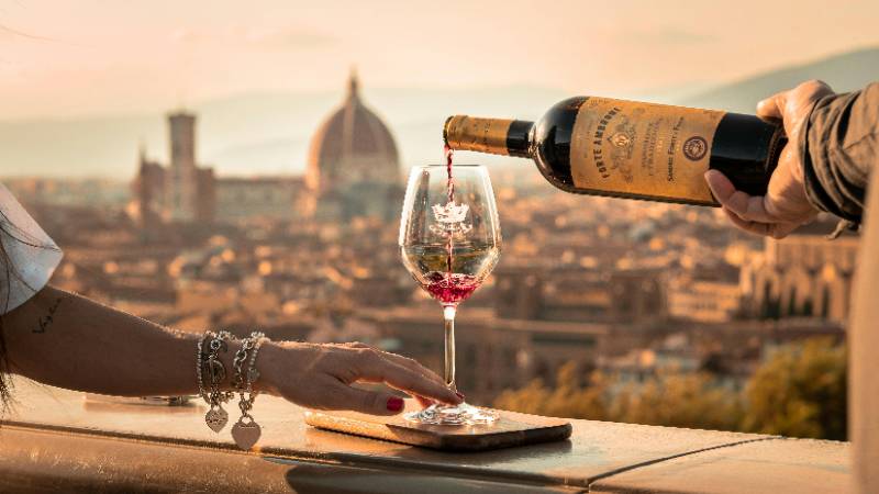 Enjoying a wine tasting experience at a vineyard in Tuscany during sunset